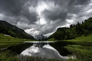 No People Waterfront Scenery Prints: Groppelensee with reflection of the Altmann summit in the background under a threatening cloudy sky