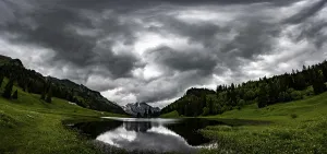 Wildhaus Appenzell Scenery Prints: Groppelensee with reflection of the Altmann summit in the background under a threatening cloudy sky