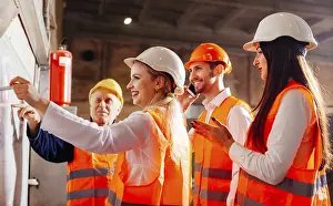 Workplace Communication Strategies Prints: The group of workers stands next by the flip chat and plans work