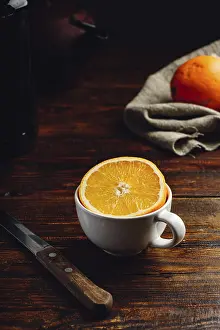 Appetizing Food Photography Ideas Prints: Half of orange in a white cup over rustic table