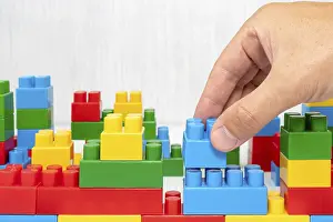Deserted Construction Site Prints: Hand building up a wall by stacking up block