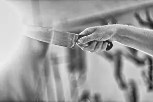 Atmospheric Backlight Shots Prints: Hand holding sharp knife, back light