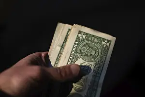 US Currency Prints: A hand holds a stack of US currency