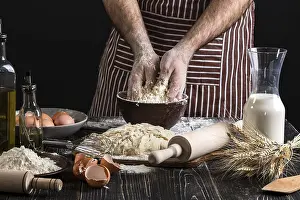 Kitchen Utensils Prints: A handful of flour with egg on a rustic kitchen
