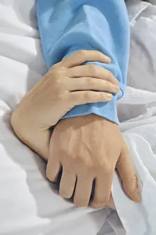Couple In Bed Prints: Two hands are held together on bed sheets
