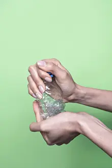 Plastic Recycling Prints: Two hands squeeze a clear plastic bottle