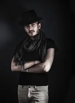 Blue Background Image Prints: Handsome young man posing with a hat