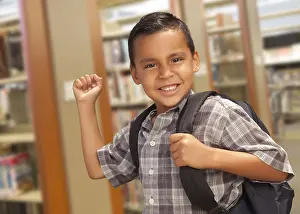 Hispanic Child Learning Prints: Happy hispanic student boy with backpack in the library
