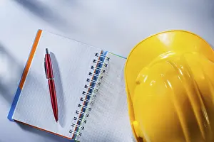 Safety Helmet Prints: Hard hat checked notepad pen on white background