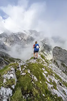 German Alps Landscape Photography Prints: Hiker looking at mountains under dramatic clouds