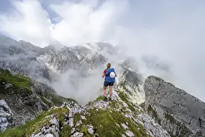 German Hiking Trails Prints: Hiker looking at mountains under dramatic clouds