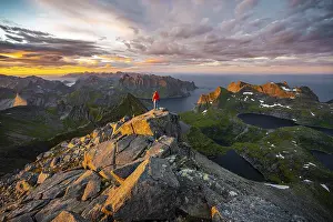 Hiker At Summit Prints: Hiker stands at the summit, sunset with dramatic clouds