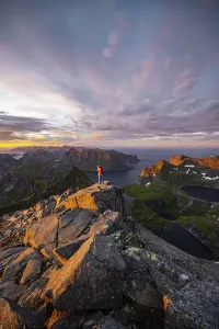 Lofoten Islands Scenic View Prints: Hiker stands at the summit, sunset with dramatic clouds