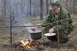 Outdoor Food Photography Prints: The hunter makes a dinner on a bonfire