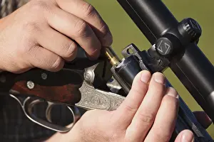 Daytime Hunting Scene Prints: Hunter reloading his rifle