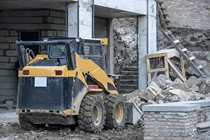 Deserted City Buildings Prints: Image of skid loader working on building construction