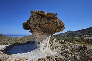 Mushroom Shaped Rocks Prints: Impressive rock formation rises in front of an extensive mountain range