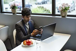 Remote Work Lifestyle Prints: A indian man multitasks efficiently using a smartphone