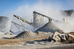 Raw Material Extraction Prints: Industrial background, crusher rock stone crushing machine at open pit mining and processing plant for crushed stone