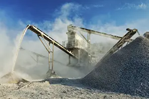 Raw Material Extraction Process Prints: Industrial background, crusher rock stone crushing machine at open pit mining and processing plant for crushed stone