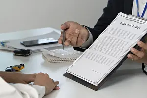 One Person Working Prints: An insurance agent presenting a policy document to a client