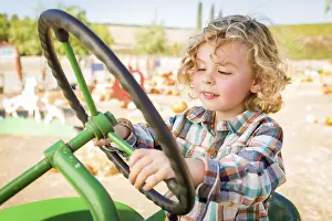 Rustic Ranch Setting Prints: Little boy having fun in A tractor in a rustic ranch setting at the pumpkin patch