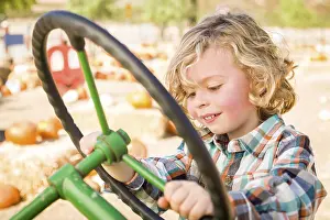 Rustic Ranch Setting Prints: Little boy having fun in A tractor in a rustic ranch setting at the pumpkin patch