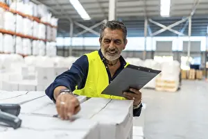 Commercial Logistics Services Prints: Logistics manager smiling while using a barcode scanner