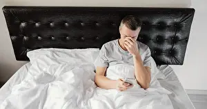 Dark Bedroom Scene Prints: Man bed using mobile