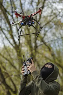 Crime Scene Photography Prints: Man in mask operating a drone with remote control