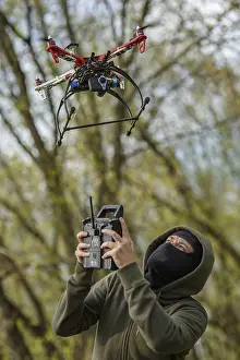 Crime Scene Photography Prints: Man in mask operating a drone with remote control