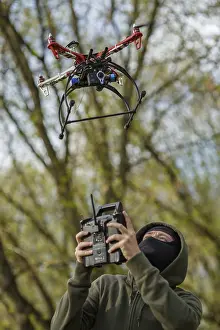 Quadcopter Aerial View Prints: Man in mask operating a drone with remote control
