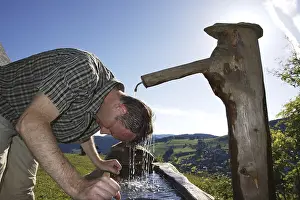 Southern Germany Historic Image Prints: A man in his mid 40s cools off at a well