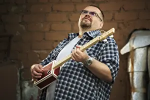 Man Playing Guitar Prints: Man playing his three string cigar box guitar