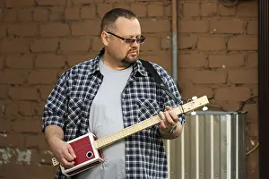 Man Playing Guitar Prints: Man playing his three string cigar box guitar