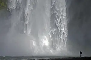 Waterfall Photography Prints: A man stands in front of an impressive waterfall