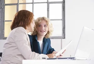 Office Work Station Setup Prints: Manager working in an office with a trainee at the computer