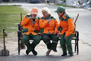 Prints of May 08, 2023. Belarus. Avitut village. A group of janitors are sitting on a bench. City cleaners Belarus Prints: Belarus. Avitut Village City Cleaners Print May 08, 2023