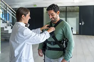 Futuristic Healthcare Prints: Mechanical exoskeleton, female physiotherapist doctor putting tapes on disabled person with robotic skeleton