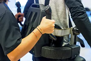 Exoskeleton Technology Prints: Mechanical exoskeleton. Female physiotherapy medical assistant helping disabled person with robotic skeleton to walk