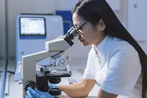 Scientific Research Lab Prints: Medical laboratory scientist perform tests on patient samples using a microscope