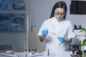Scientific Research Lab Prints: Medical laboratory scientist perform tests on patient samples using a microscope