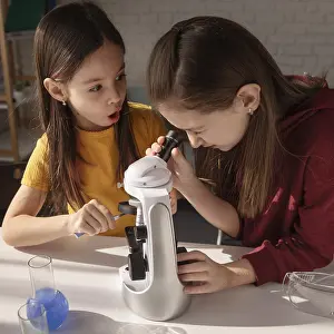 Scientific Experimentation Prints: Medium shot girls learning with microscope