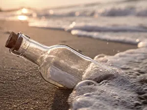 Environmental Pollution Effects Prints: Message in the bottle washed ashore against the Sun setting down