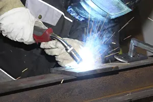 Industrial Equipment Prints: Metalworker during welding work in his workshop