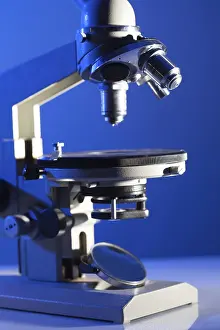Biotechnology Research Prints: Microscope on the table in laboratory with blue light