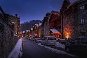 Prints of Modern stone houses and apartments illuminated by street lights in El Tarter village at dusk or night fall in Pyrenees mountains, Grandvalira, Andorra Andorra Prints: Modern Stone Houses at Dusk in El Tarter Village Print