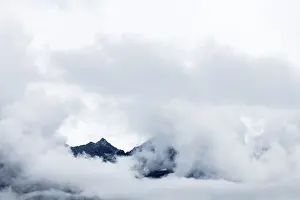 Cloudy Mountain Peak Prints: Mountain peak rises from clouds