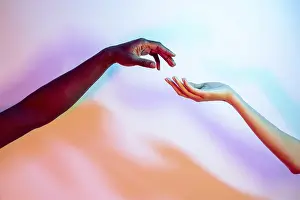 Vibrant Gradient Background Prints: Two multiethnic hands reaching towards each other