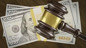 High Angle Shot Prints: Overhead of gavel resting on a table and stack of thousands of dollars